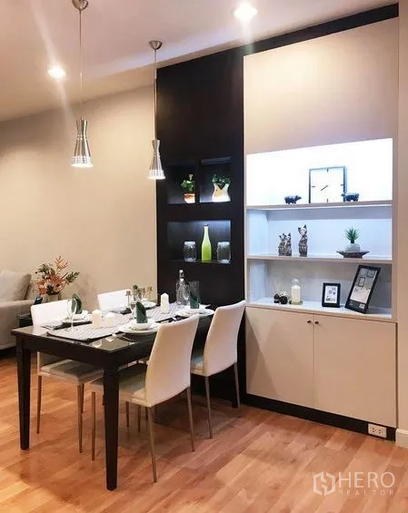 Condominium for rent in Khlong Toei, Bangkok - Dining nook with illuminated shelving, four-seat table, and pendant lighting.