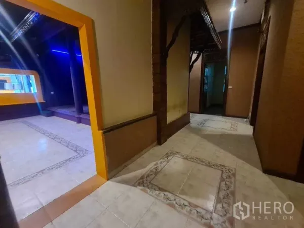 Retail Space for rent in Watthana, Bangkok - Corridor with patterned tiles opening to a purple retail room with a raised platform.