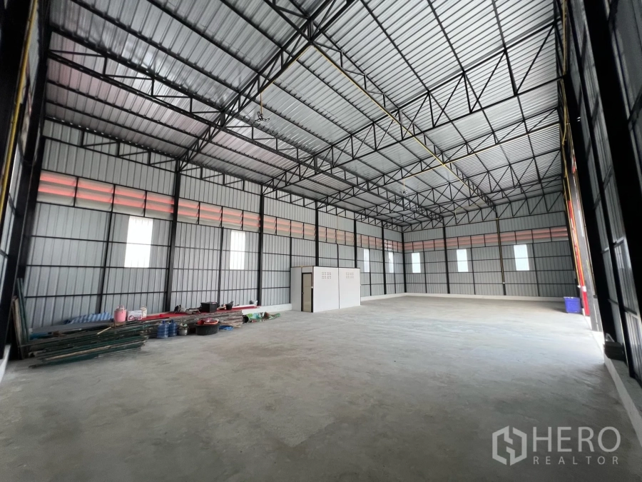 Warehouse for rent in Lam Luk Ka, Pathum Thani - High-ceiling steel-frame warehouse interior with concrete floor and windows, approx. 270 sqm.