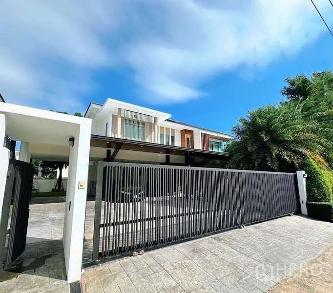 Detached House for rent or sale in Bang Phli, Samut Prakan - Modern two-storey detached house in Bang Phli with wide sliding black gate and paved driveway.