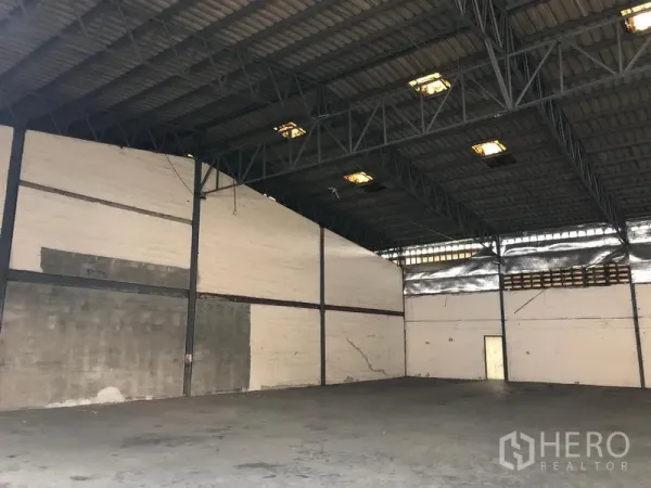 Warehouse for rent in Bang Phli, Samut Prakan - Spacious empty warehouse interior with high steel truss roof and durable concrete floor.