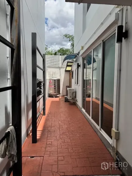 Detached House for sale - Side terrace with red stamped-concrete flooring, sliding glass doors, and outdoor AC units.