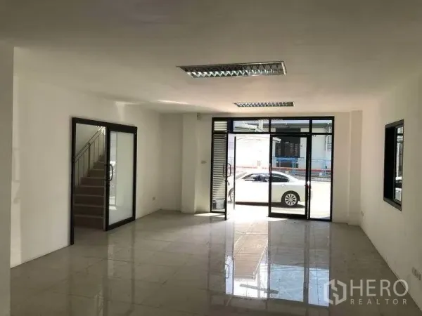 Factory for rent or sale in Bang Phli, Samut Prakan - Bright ground-floor office with tiled floors, glass frontage and a staircase to the upper level.