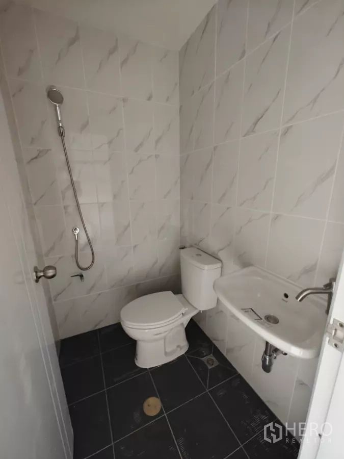 Warehouse for rent in Sam Phran, Nakhon Pathom - New tiled bathroom with toilet, sink and handheld shower.