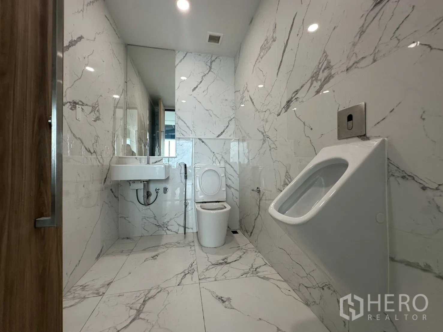 Office Space for rent in Din Daeng, Bangkok - Marble-tiled men’s restroom with sink, toilet, and urinal.