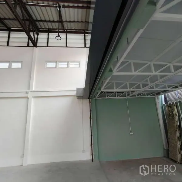 Shophouse for rent in Khlong Toei, Bangkok - Detail of high white walls, clerestory windows and green partition under mezzanine.