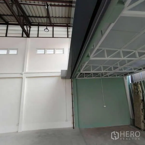 Shophouse for rent in Khlong Toei, Bangkok - Detail of high white walls, clerestory windows and green partition under mezzanine.
