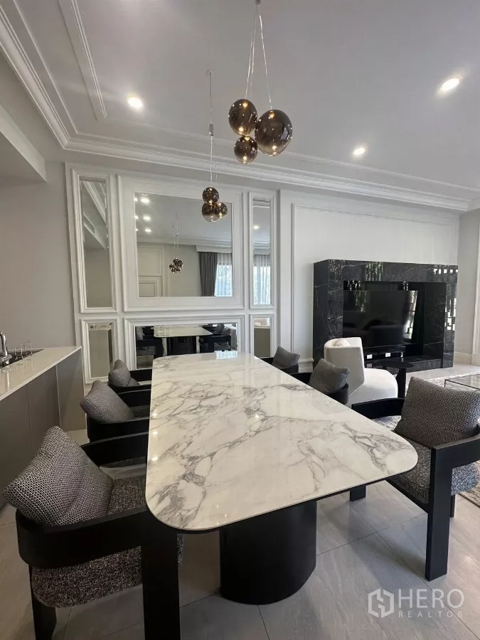Detached House for rent or sale in Bang Kapi, Bangkok - Close-up of the dining table with pendant lights, mirrors and marble finishes.