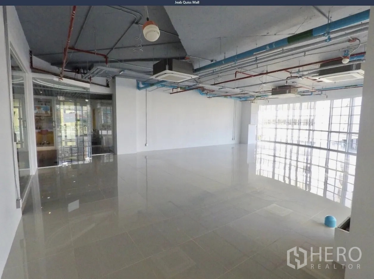 Office Space for rent in Khlong Toei, Bangkok - Spacious office area with polished flooring, glass partition entry, and modern exposed ceiling.