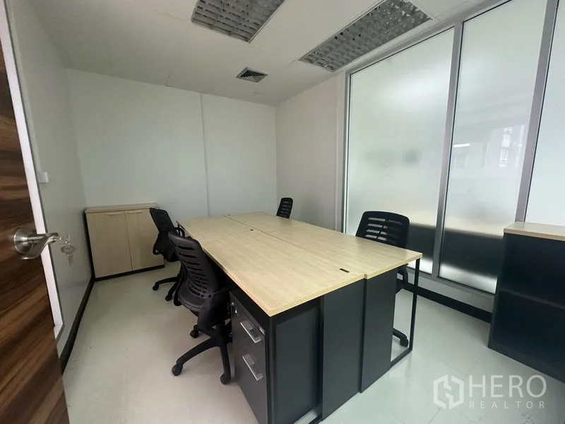 Office Space for rent - Private office room with two facing desks, rolling chairs, and frosted window panels.