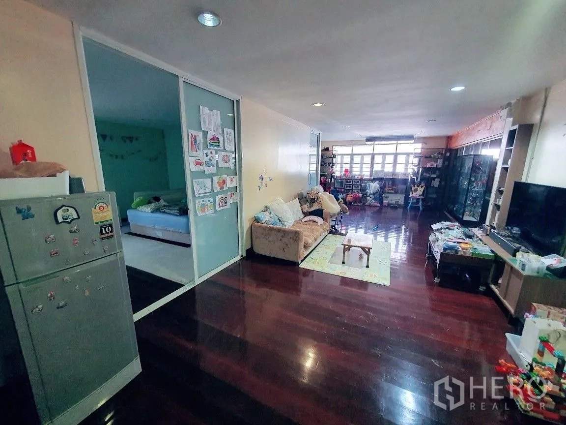 Warehouse for rent in Lam Luk Ka, Pathum Thani - Open family room with sofa, sliding glass bedroom door and refrigerator.