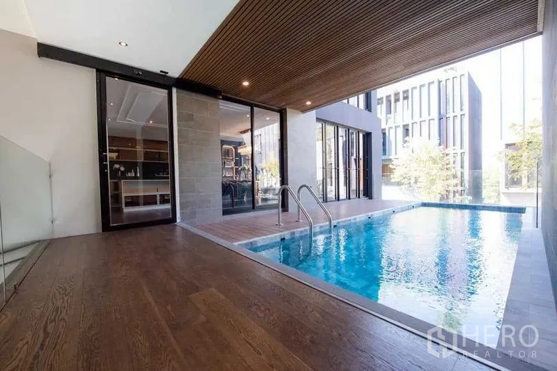 Detached House for sale in Prawet, Bangkok - Covered private swimming pool with wood ceiling and glass doors connecting to the interior.
