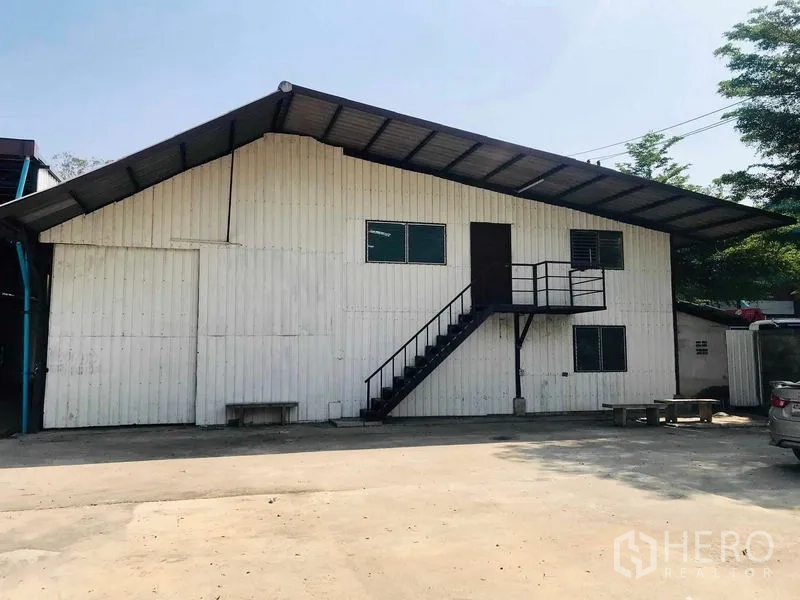 货栈 出租在Pathum Thani - 仓库临街外立面，上层入口楼梯与宽阔硬地。