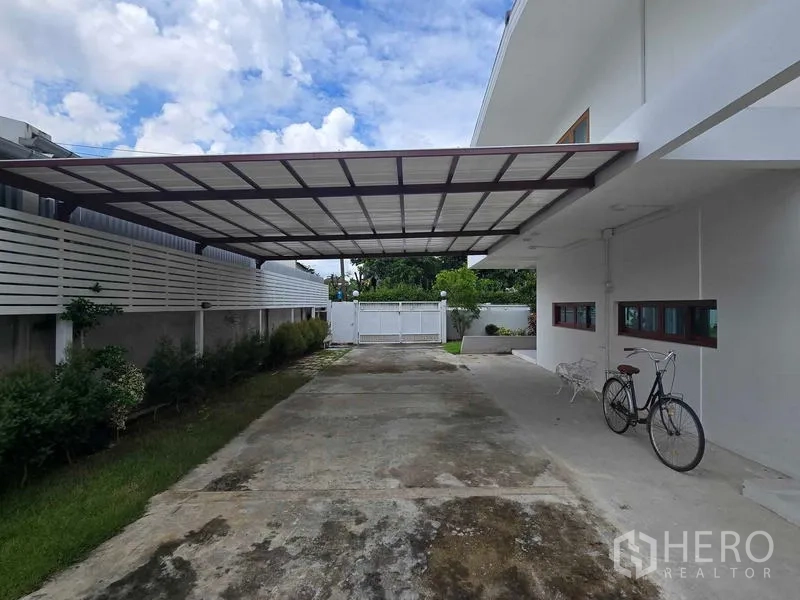 Home Office for rent - Covered carport and driveway beside the house leading to a gated entrance.