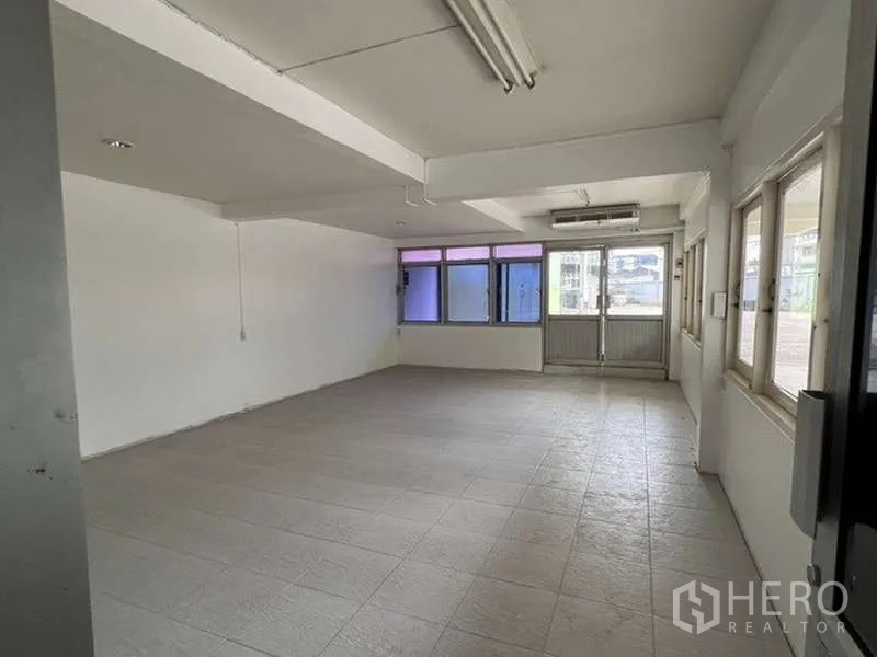 Warehouse for rent - Bright office room with tiled flooring, windows and air-conditioning unit.