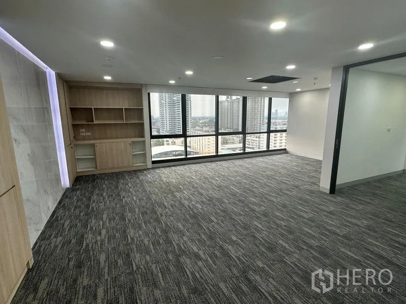 Office Space for rent in Khlong Toei, Bangkok - Executive corner office with built-in shelving and wide city skyline view.