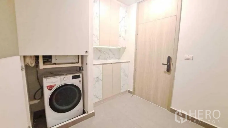 Condominium for rent or sale in Pathum Wan, Bangkok - Laundry cabinet with front-load washing machine near the entrance.