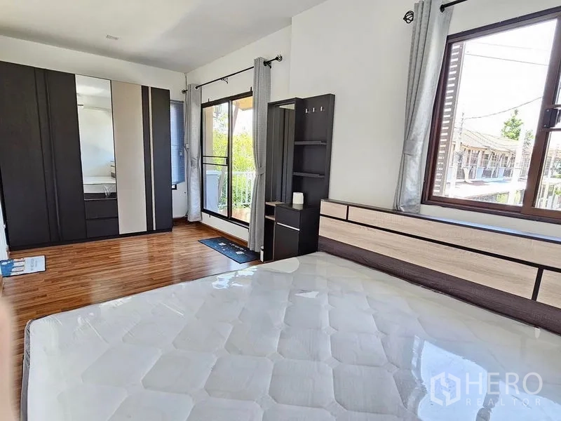 Townhouse for rent - Master bedroom with wood flooring, large wardrobe and door to the balcony.