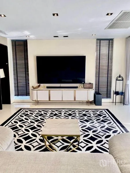 Detached House for rent in Suan Luang, Bangkok - Media lounge with wall-mounted TV, console unit and a bold patterned rug.