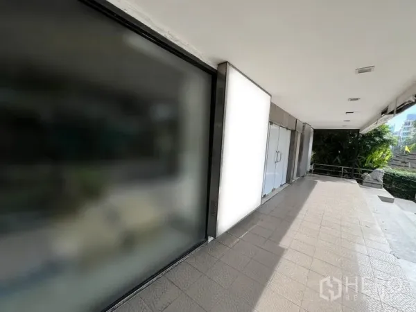Retail Space for rent in Watthana, Bangkok - Covered walkway with wide tiled terrace and glass storefront of a retail unit in Phrom Phong, Bangkok.