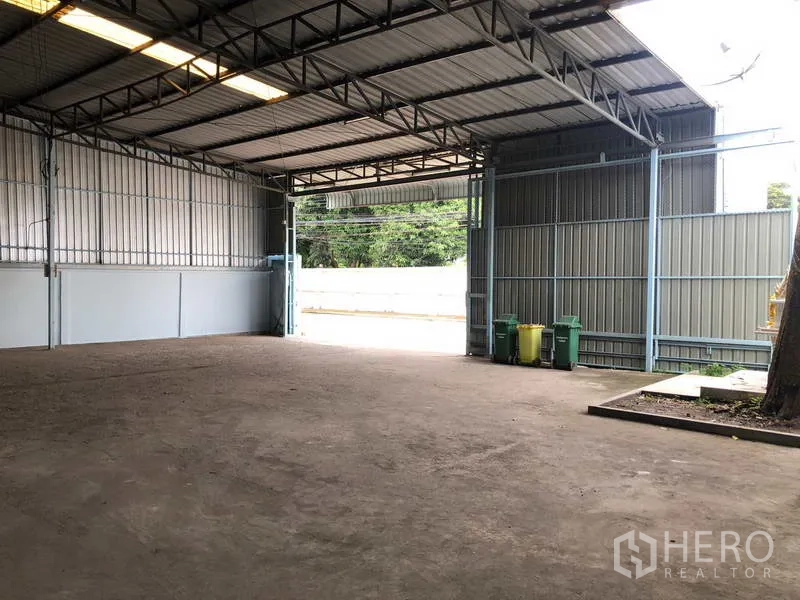 Warehouse for rent in Sai Noi, Nonthaburi - Covered loading bay opening to the road with wide entry and metal gates.