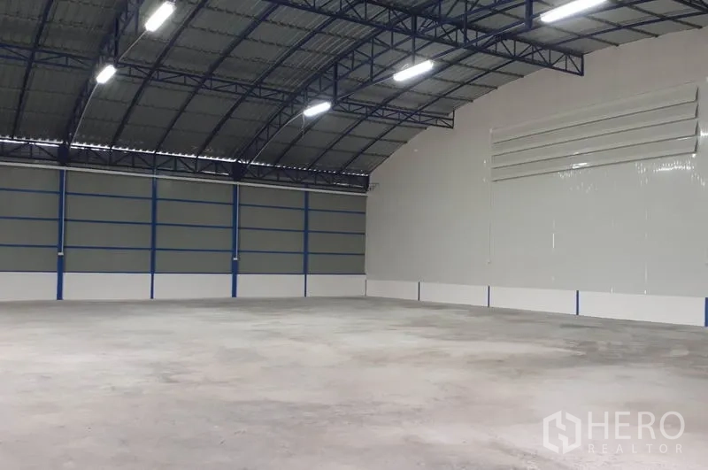 Warehouse for rent in Nong Chok, Bangkok - Large clear-span warehouse with curved roof, bright LED lighting and ventilated wall panels.