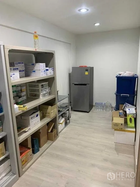 Retail Space for rent in Pathum Wan, Bangkok - Compact storage room with open shelving, boxes and a refrigerator on light wood flooring.