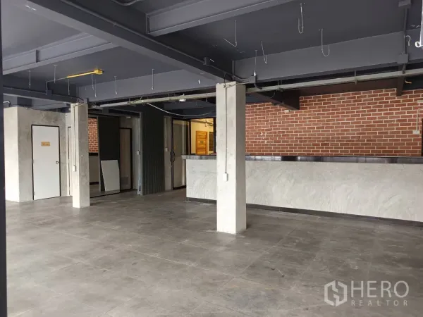 Retail Space for rent in Watthana, Bangkok - Retail floor showing service counter, multiple doors and a brick accent backdrop.