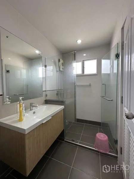 独立式住宅 出售在Sai Mai, Bangkok - 套内浴室，洗手台、大镜与玻璃淋浴。