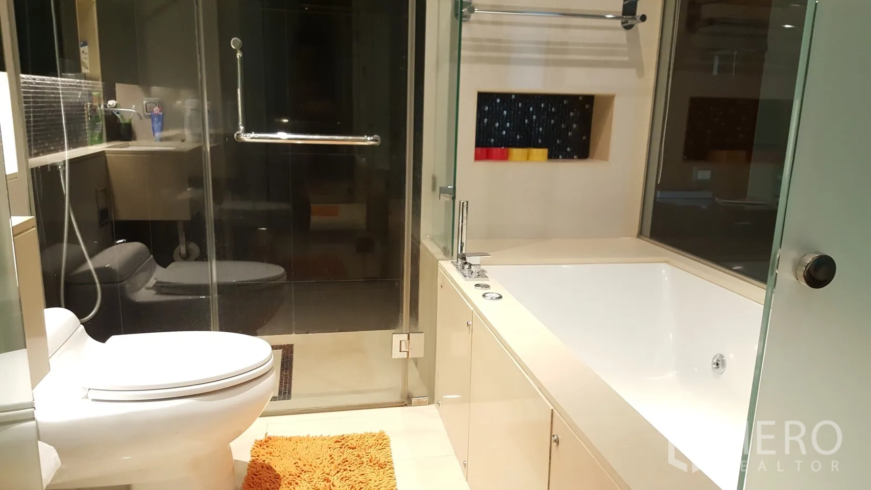 Condominium for rent or sale in Khlong Toei, Bangkok - Modern bathroom with glass-enclosed shower, large soaking bathtub and toilet.