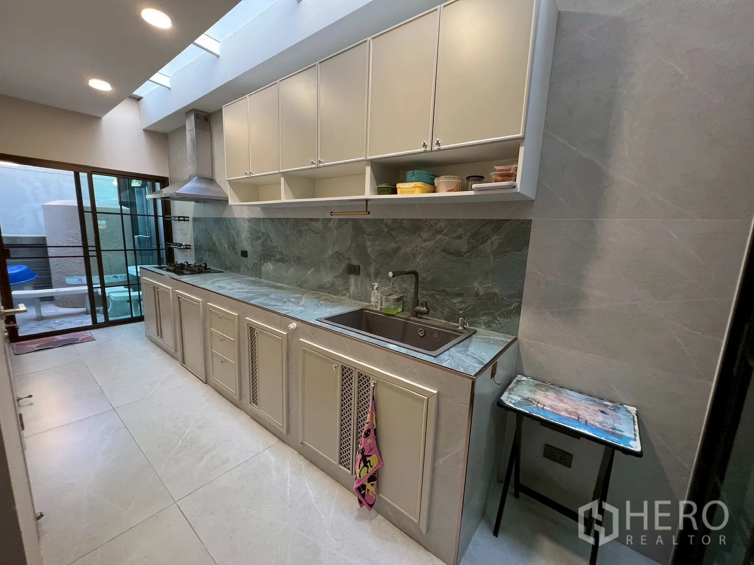 Detached House for rent in Bang Kapi, Bangkok - Full Thai kitchen with gas hob, range hood, ample cabinetry, and tile floors.