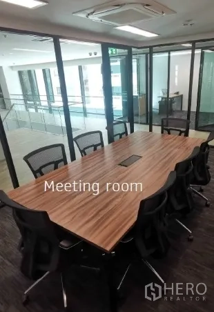 Office Space for rent in Khlong Toei, Bangkok - Glass-walled meeting room with long wooden conference table and ergonomic chairs in a modern office.