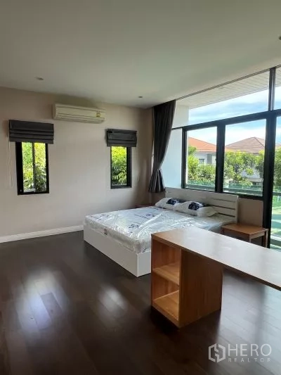 Detached House for rent in Bang Kapi, Bangkok - Corner bedroom with wide windows, garden views and bedside tables.
