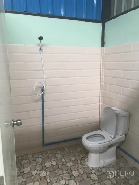 Warehouse for rent in Khlong Luang, Pathum Thani - Clean restroom with shower, tiled walls and floor inside the warehouse.