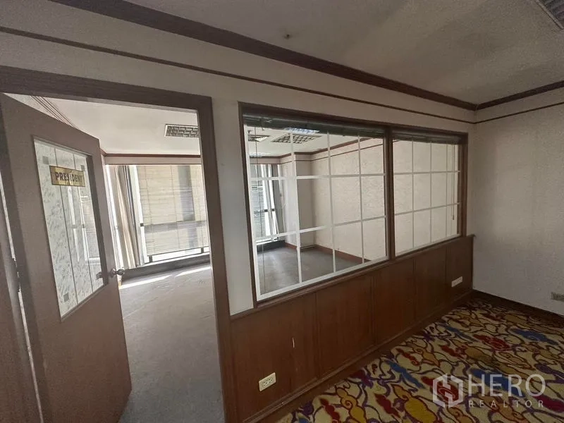 Office Space for rent - Interior hallway with wood-trimmed glass partitions linking meeting rooms with city-view windows.