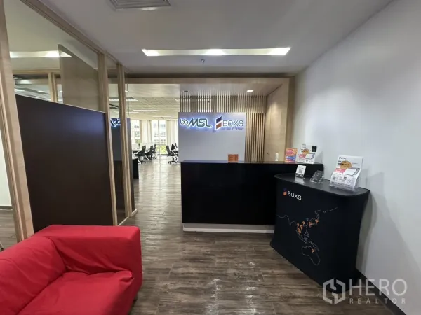 Office Space for rent - Reception area with black counter, brochure stand, and a view into the open-plan workspace.
