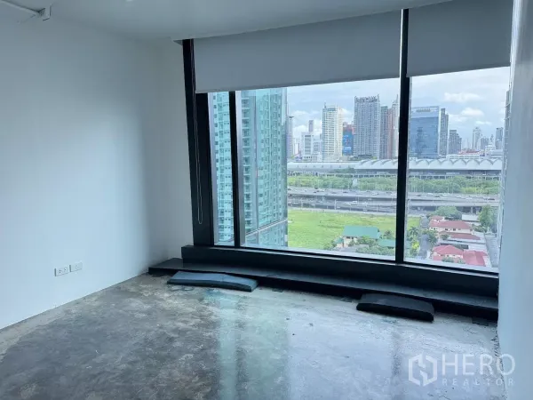 Office Space for rent in Din Daeng, Bangkok - Private corner room with a large window looking out to city towers and green space.