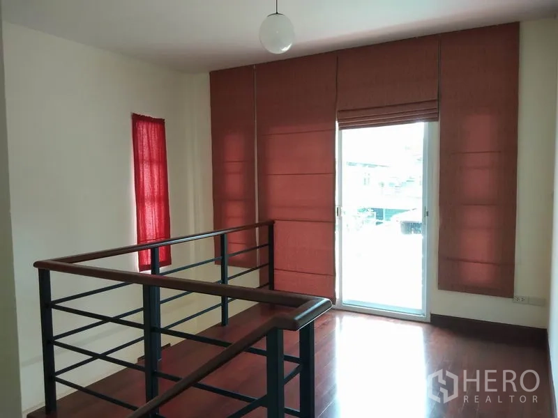 Detached House for rent in Watthana, Bangkok - Stair landing with metal railing, red blinds and a glass door to the balcony.