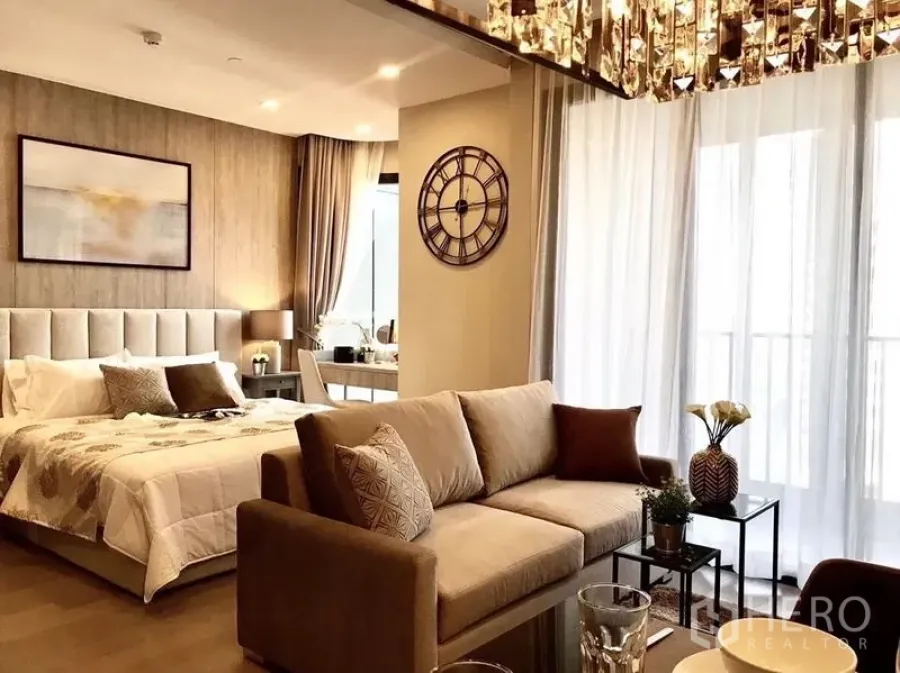 公寓 出租在Watthana, Bangkok - 开放式客厅与卧室布局，配沙发、软包床、落地窗与纱帘
