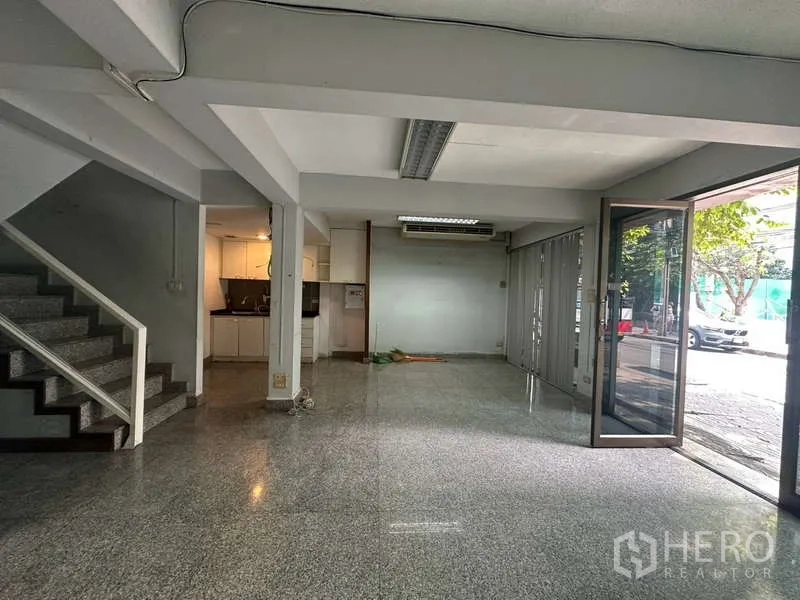 店屋 出租在Khlong Toei, Bangkok - 底层开放空间，楼梯与折叠玻璃门