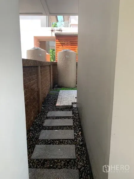 Detached House for sale in Prawet, Bangkok - Narrow side passage with stepping stones leading to an outdoor utility area.