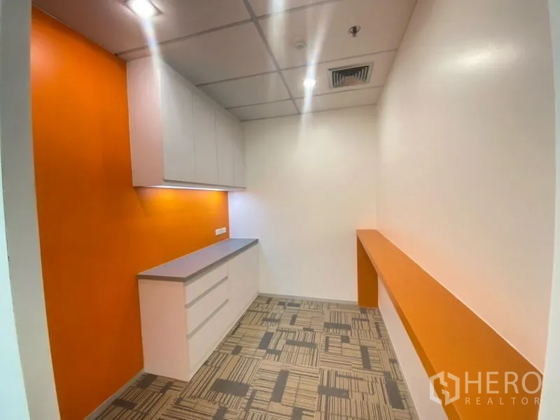 Office Space for rent in Chatuchak, Bangkok - Built-in pantry with orange accent wall, overhead cabinets, and countertop in the office.