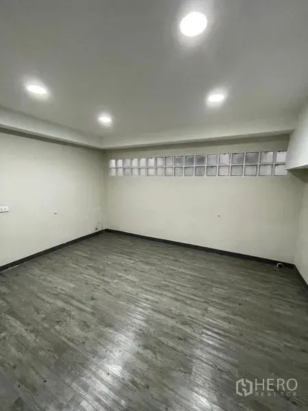 Home Office for rent in Chatuchak, Bangkok - Enclosed room with gray wood-look flooring and glass block clerestory windows.