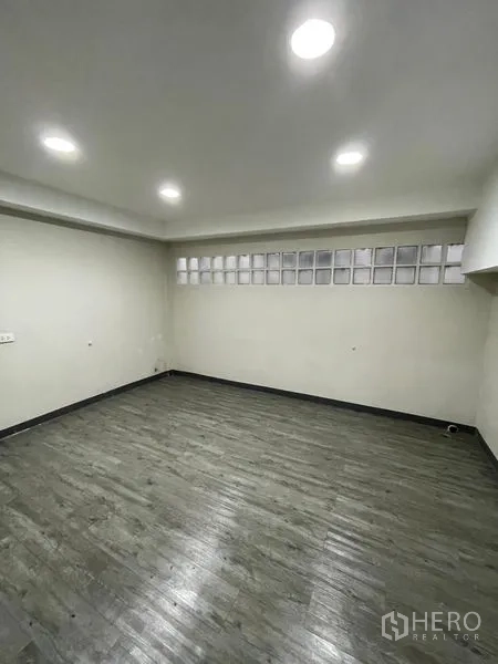 Home Office for rent in Chatuchak, Bangkok - Enclosed room with gray wood-look flooring and glass block clerestory windows.