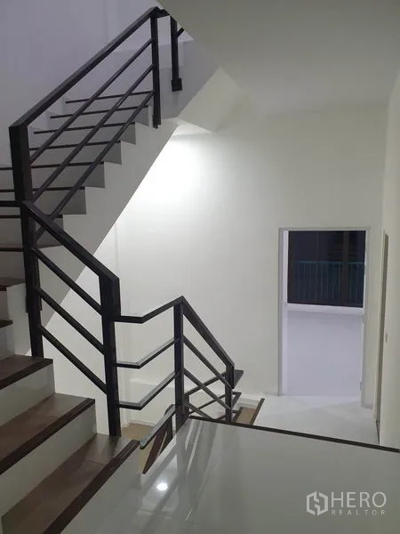 Home Office for rent in Wang Thonglang, Bangkok - Minimalist staircase with metal handrails leading to a doorway and upper floor.