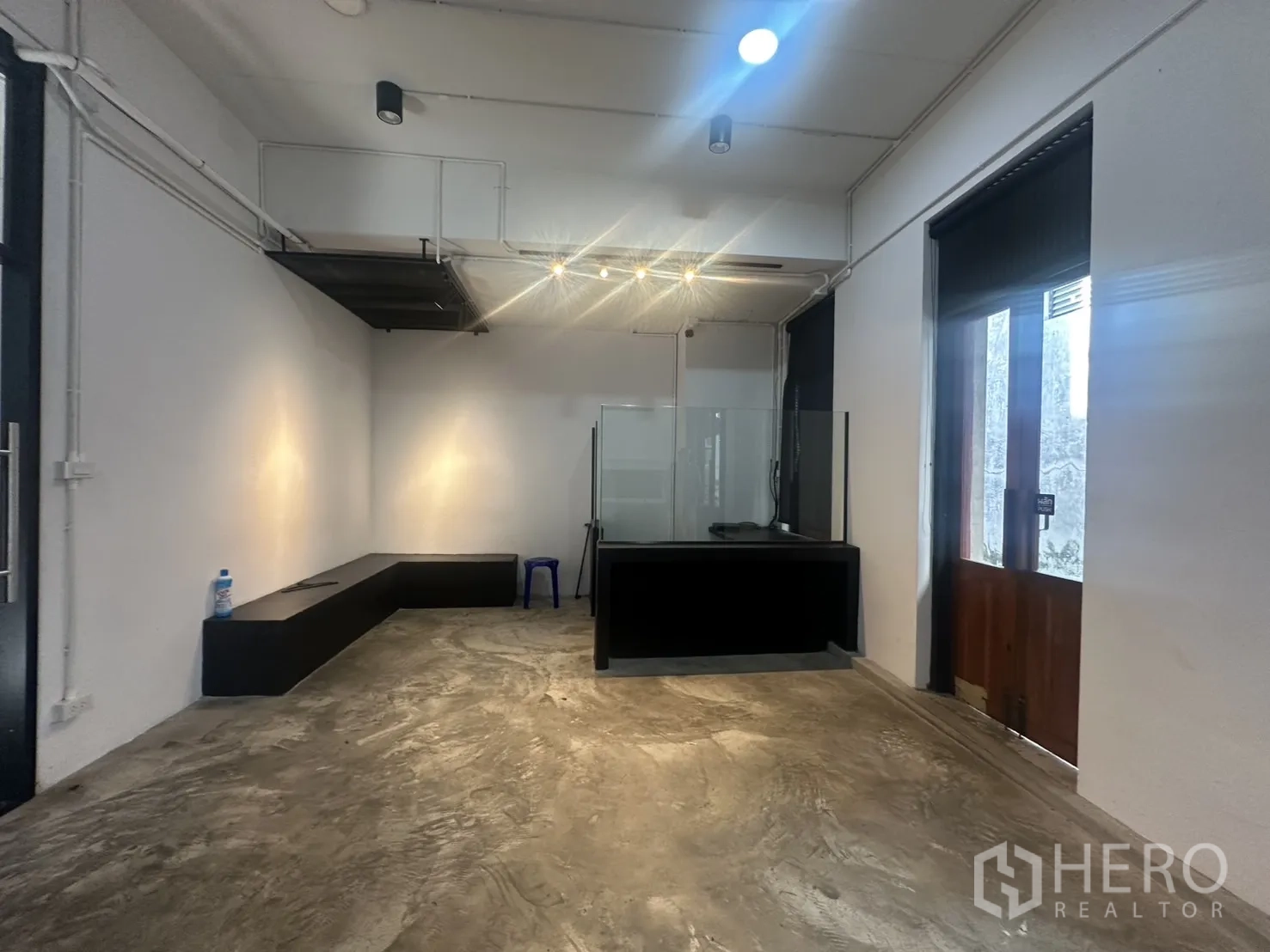 Home Office for rent in Pathum Wan, Bangkok - Ground-floor retail-ready space with polished concrete floor, reception counter and glass doors.