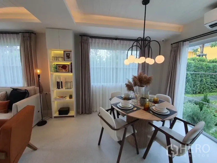Detached House for rent in Prawet, Bangkok - Bright dining area with round table, globe pendant light and garden-view windows.