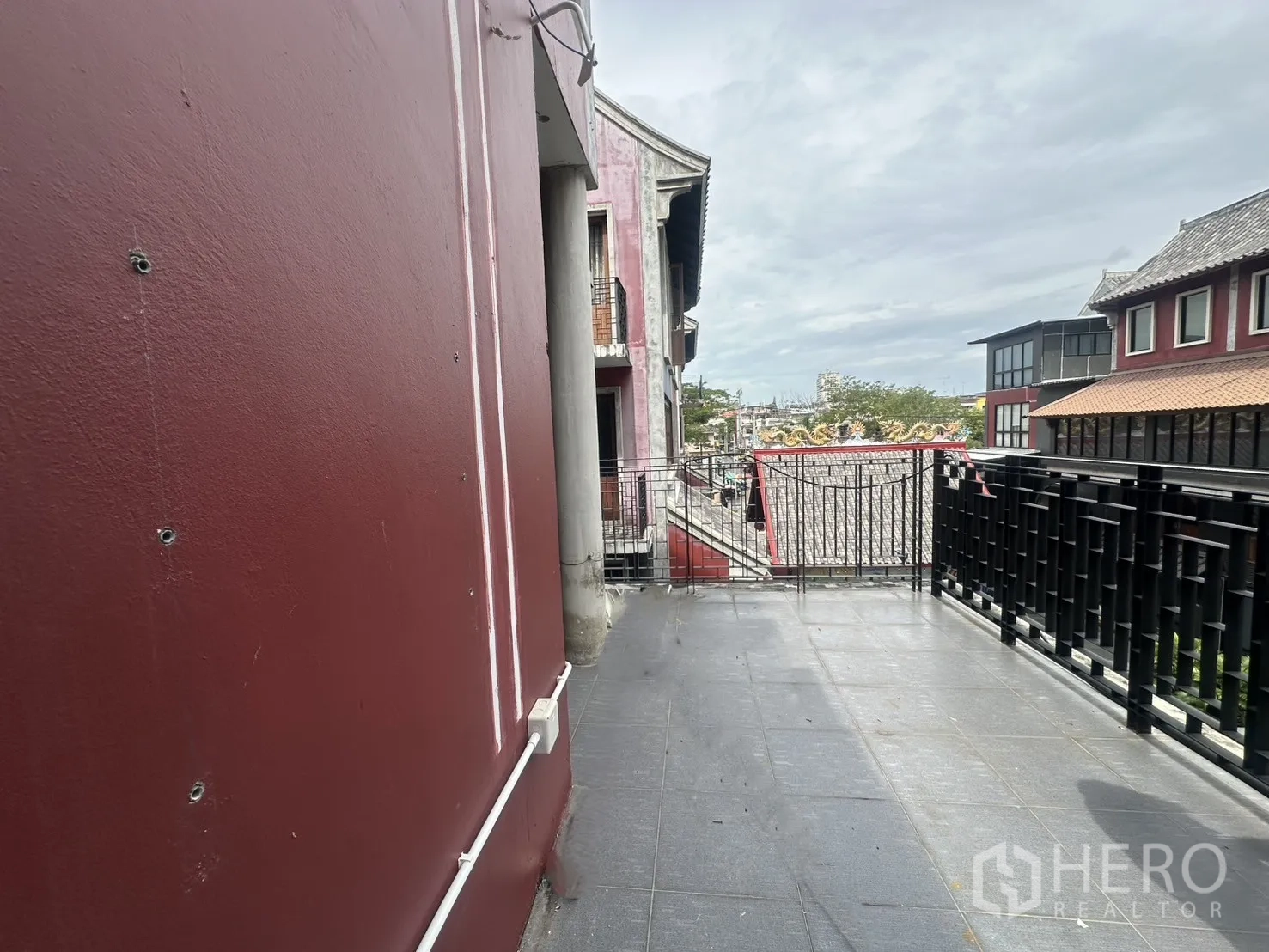 Home Office for rent in Pathum Wan, Bangkok - Wide side balcony with black metal railing overlooking a pedestrian lane of the complex.