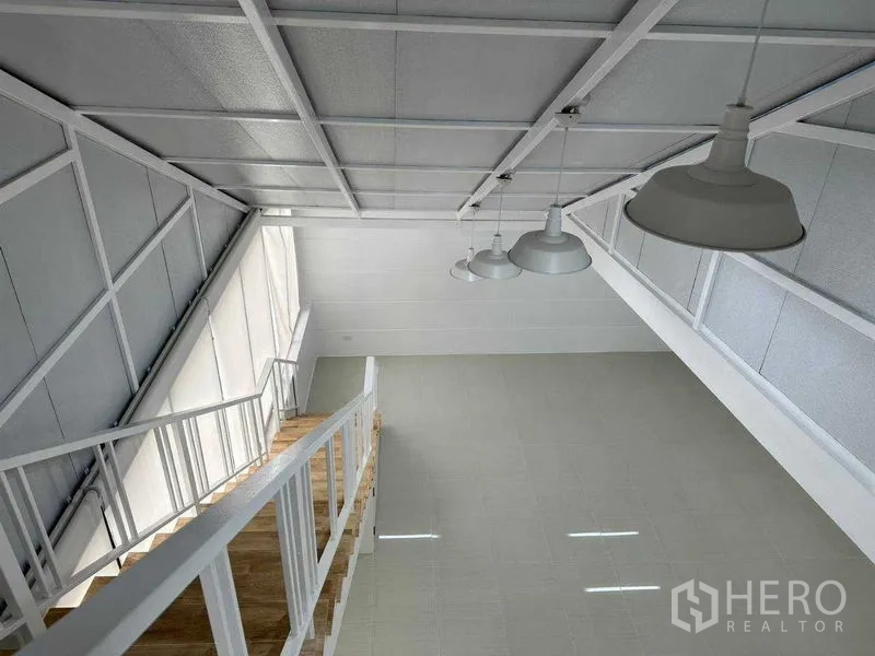 办公空间 出租或出售在Khlong Toei, Bangkok - 从夹层向下俯瞰，见吊灯、斜屋顶与整面窗墙。