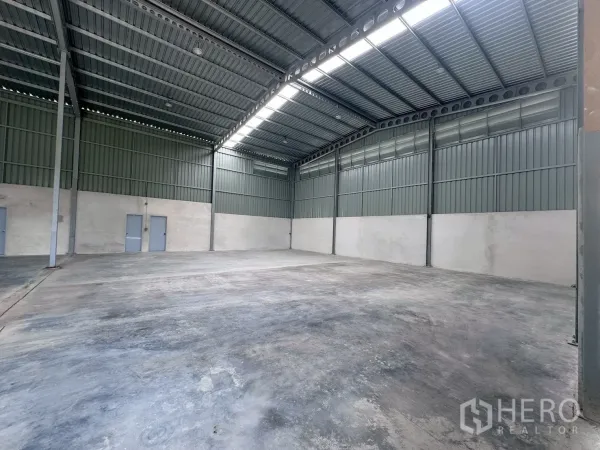 Warehouse for rent in Khlong Luang, Pathum Thani - Spacious warehouse interior with high steel roof, ridge skylights and concrete floor.